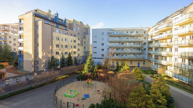 Un'area giochi circondata da palazzi con balconi.