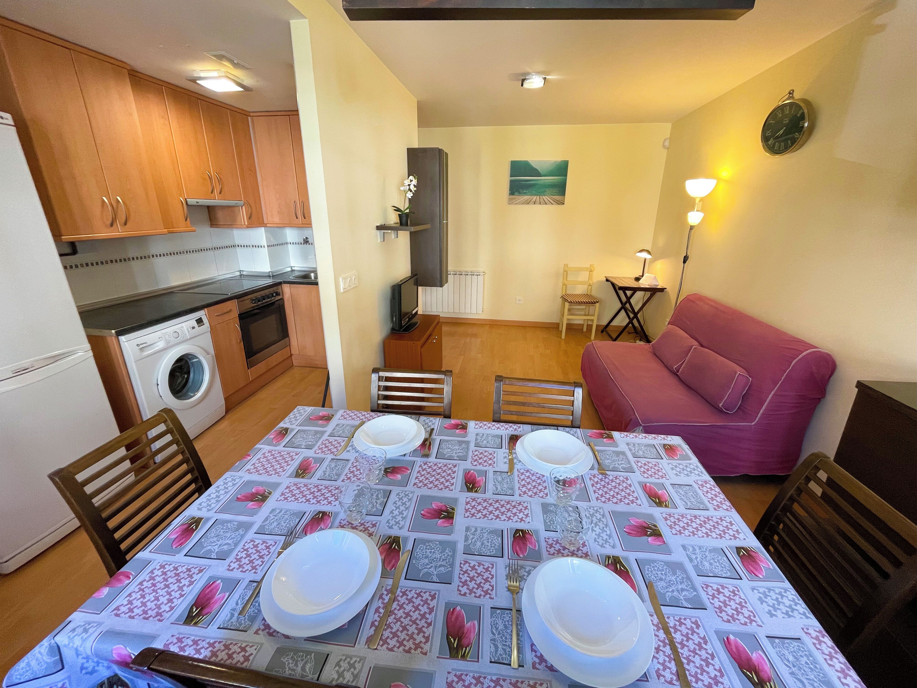 A compact living space with a kitchen, dining area, and a sofa.