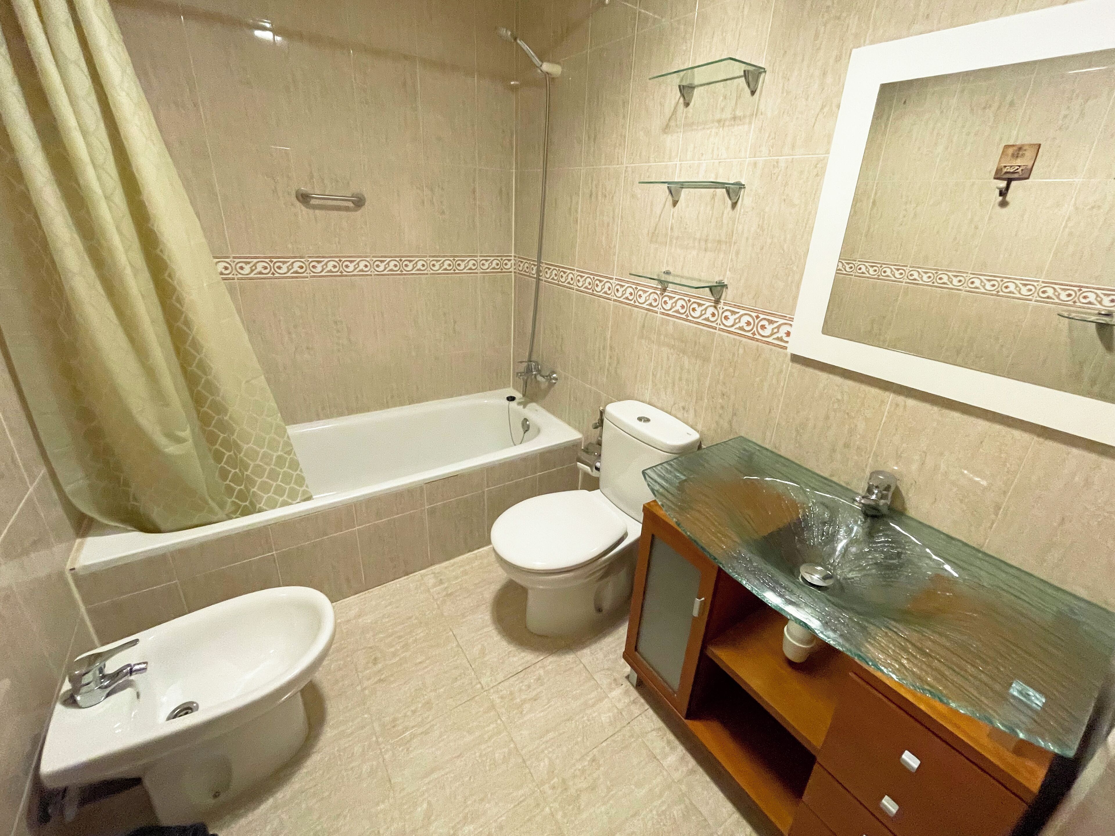 Un baño con bañera, inodoro, lavabo y cabina de ducha de vidrio.