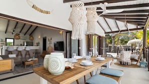 A modern kitchen with a wooden island, bar stools, and hanging macrame lights. - Waterlands Village Bonaire, Kas Palma with private pool! (Kralendijk)