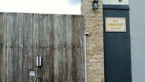 A wooden gate with a padlock, a stone wall, and a sign that reads "Bale JIWAN MUKTI Narmada." - Bale Jiwanmukti Narmada (Narmada)