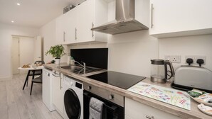 Een moderne keuken met een inbouwfornuis, een koffiezetapparaat en een broodrooster.