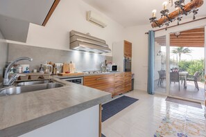 A modern kitchen with a built-in oven, stainless steel sink, and wooden cabinets.