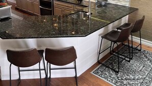 A modern kitchen with a large island, bar stools, and pendant lighting. - 3-bedroom townhome in fabulous Longboat Key with stunning views and boat dock (Longboat Key)
