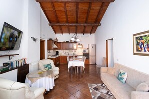 A cozy living room with a TV, sofa, and dining area. - Villa Jelu with Mountain View, Wi-Fi and Air Conditioning (Castiglione di Sicilia)