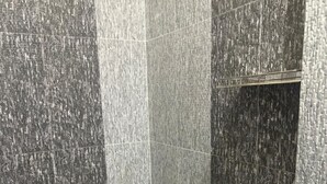 Un baño con inodoro y lavamanos blancos, y una zona de ducha.