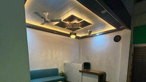 Una sala moderna con un sofá azul, una mesa de centro de madera y un ventilador de techo.