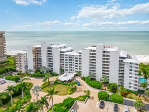 Ein Hochhaus-Hotel mit mehreren Etagen, einem zentralen Innenhof und Blick auf Strand und Meer.