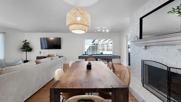 Een moderne woonkamer met een houten eettafel, een bank en een televisie.