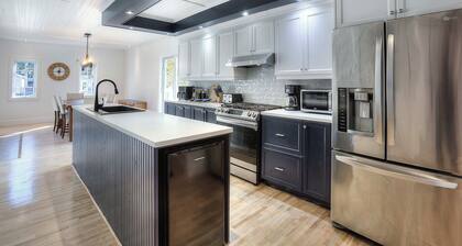 Escape to our 100-year-old ancestral home on 23 private acres by Lac Jolicoeur. This lakefront retreat is perfect for large groups of up to 15, offering year-round magic with a private hot tub, stone fireplace, and game room.