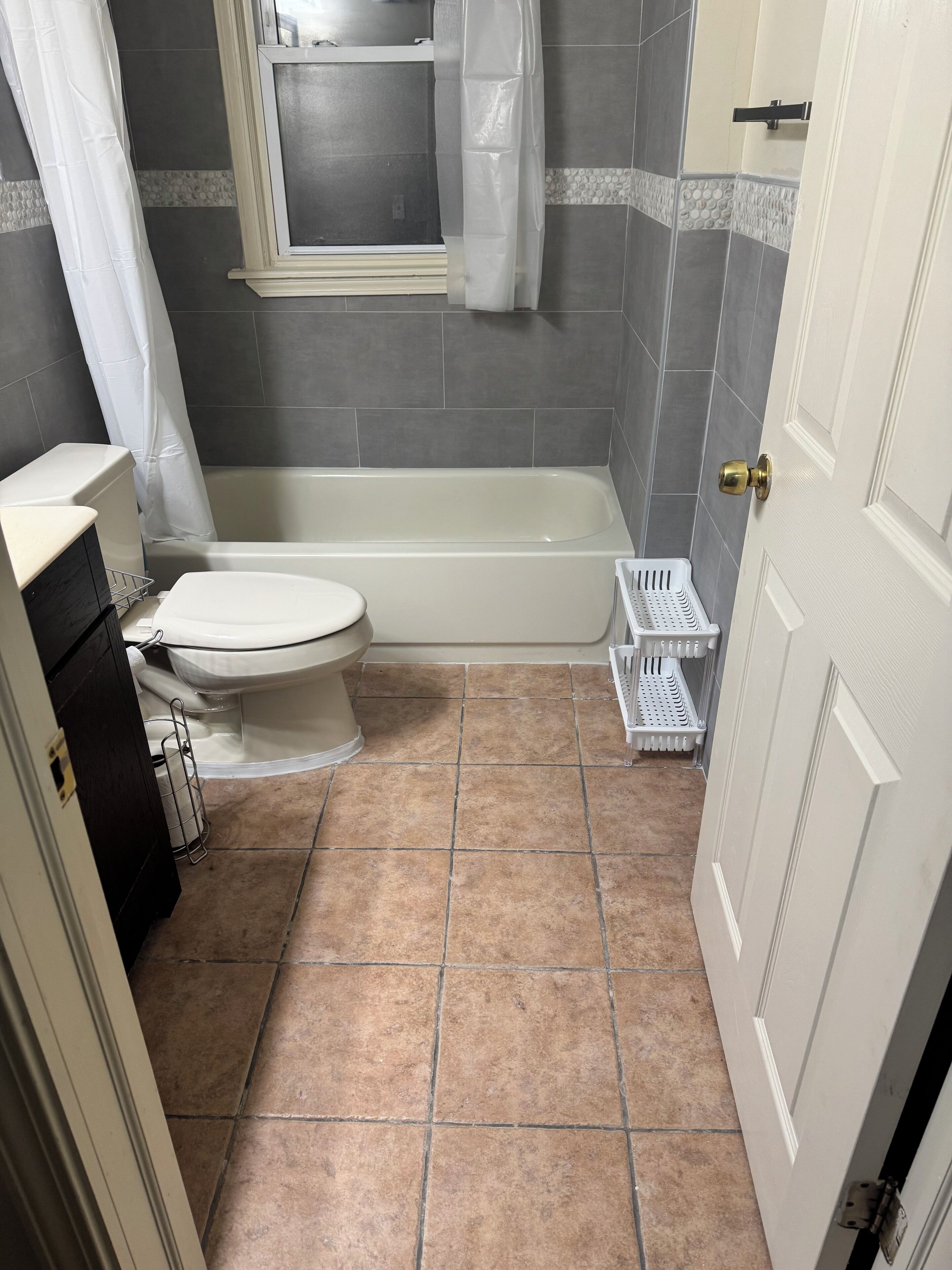 A bathroom with a bathtub, toilet, and a shower curtain.