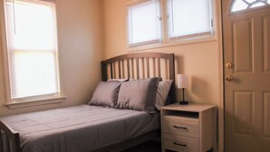 A bedroom with a bed, nightstand, and a door. - Downtown Detroit Getaway (Detroit)