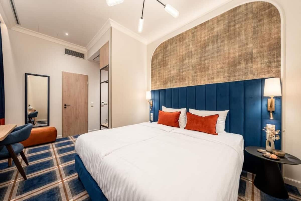 Una habitación de hotel con una cama grande, un escritorio y una silla.