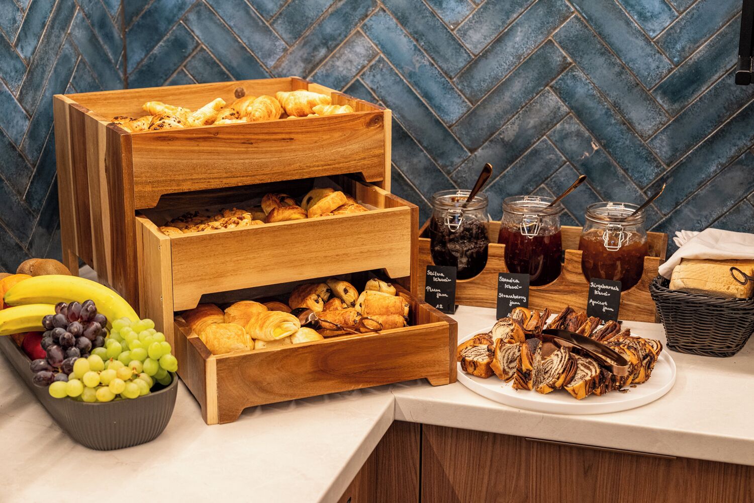 Um buffet de café da manhã com pães, frutas e geleias.