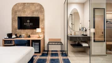 Une chambre d’hôtel équipée d’un lit, d’un bureau et d’un téléviseur fixé au mur.