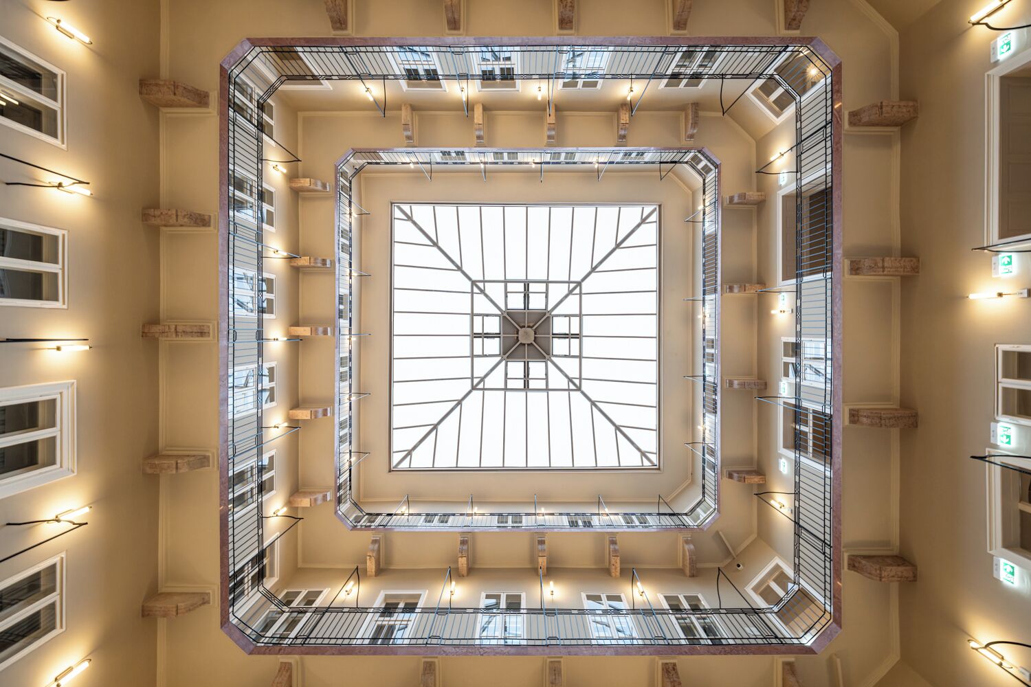 A high-ceiling atrium with a central skylight, multiple balconies, and a symmetrical layout.