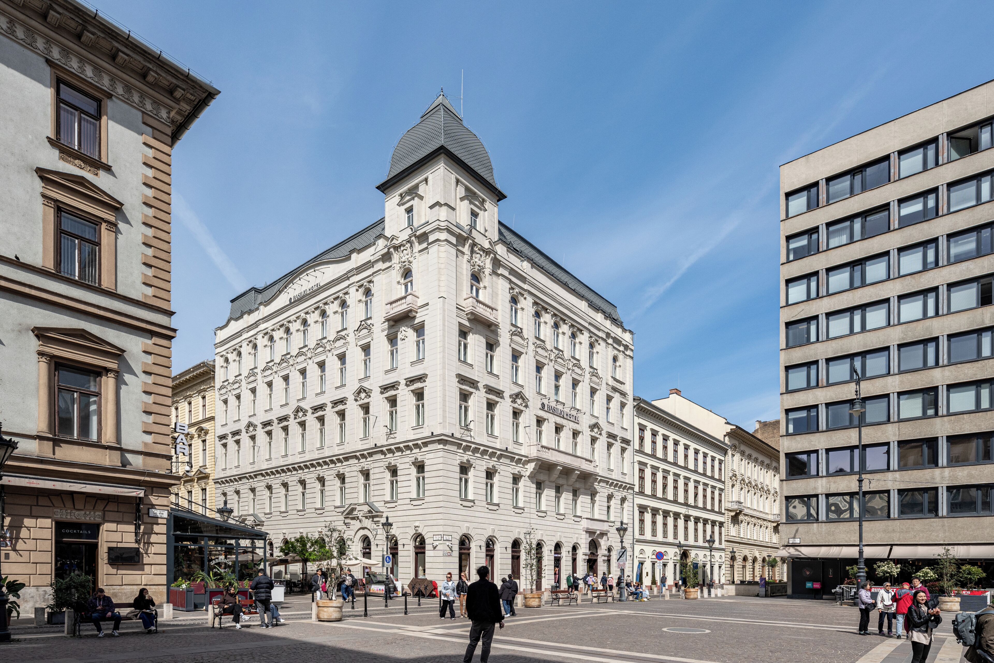 Un bâtiment historique à l’architecture classique, doté d’un dôme central et d’une cour intérieure aménagée avec des espaces de repos.