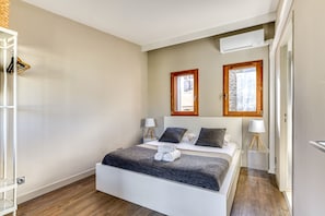 A neatly arranged bedroom with a bed, two bedside tables, a wardrobe, and a window. - La Verriere in Montpellier (Montpellier)