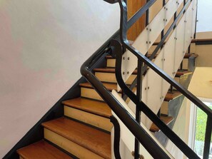 Eine Treppe mit Holzbodenstufen und schwarzen Metallgeländern.