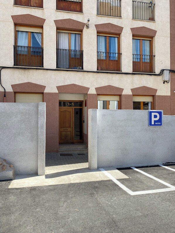 A building with a parking sign, a gated entrance, and a number '3-5' sign. - Apartamento el rosario (Corella)