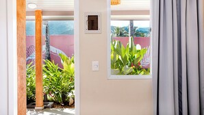 A room with a view of lush greenery and a mural on the wall. - Azul da Cor do Mar (São Sebastião)