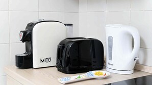 Eine Küchenarbeitsfläche mit Kaffeemaschine, Toaster und Wasserkocher.