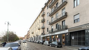 A row of parked cars along a street with a building featuring a storefront labeled "CENTRO VENETO DEL MOBILE." - Brera Apartments Navigli (Milan)