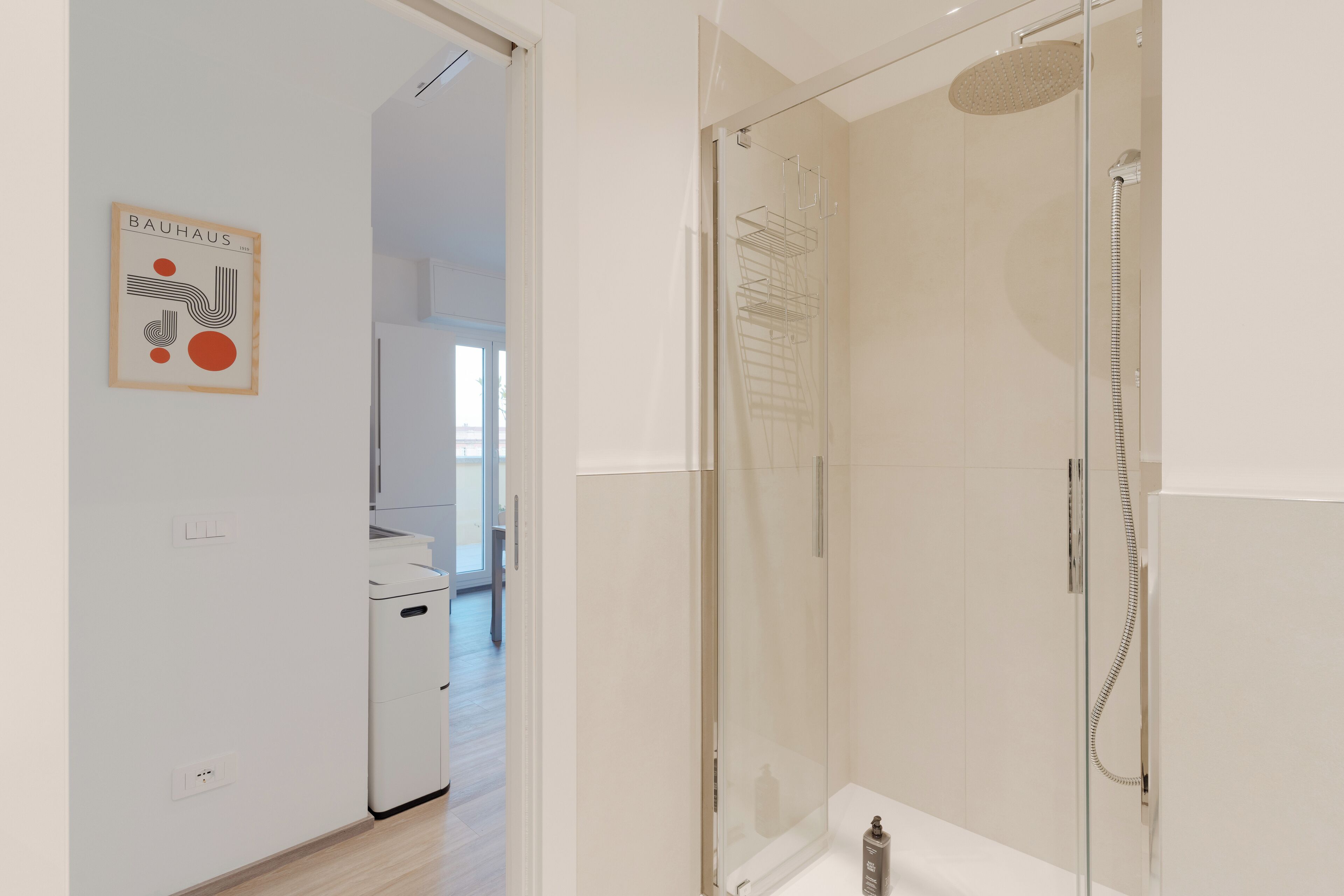 A modern bathroom with a glass-enclosed shower, a toilet, and a sink.