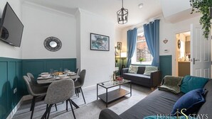 Ein modernes Wohnzimmer mit Sofa, Couchtisch und Essbereich.