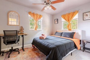 A bedroom with a bed, desk, chair, and a ceiling fan. - Charming 3-bedroom House with Office Space-Close to UF & Shands Hospital (Gainesville)