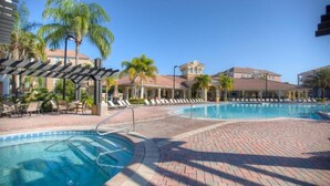 Ein Poolbereich eines Resorts mit Liegestühlen und Palmen.