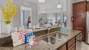 A modern kitchen with granite countertops, stainless steel appliances, and a double sink. - Spacious 4BR Vista Cay Retreat near Universal (Orlando)