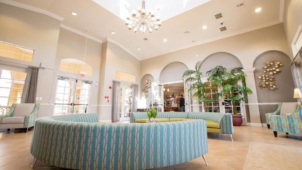 A spacious lobby with a high ceiling, a central seating area, and large windows allowing natural light. - Vista Cay 3BR Condo near Universal (Orlando)