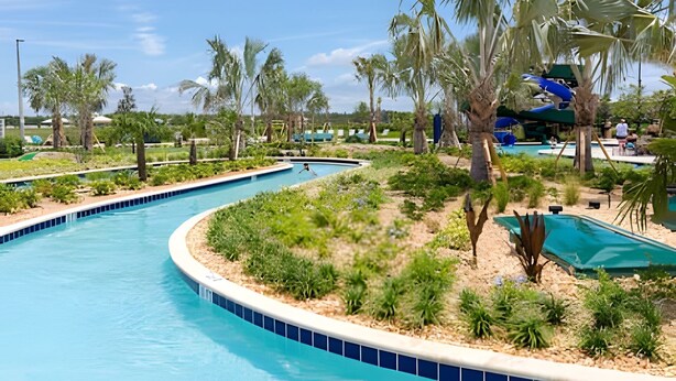 A pool area with multiple swimming pools, palm trees, and a water slide. - 4BR Storey Lake Home, Sleeps 10 (Kissimmee)