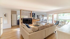 Ein modernes Wohnzimmer mit Sofa, Fernseher und Essbereich.