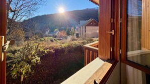 Eine Holzhütte mit einem Balkon mit Blick auf eine Berglandschaft.