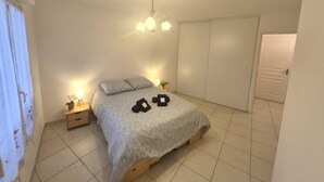 A bedroom with a bed, bedside table, lamp, and a wardrobe. - Comfortable stay in the heart of La Seyne-sur-Mer (La Seyne-sur-Mer)
