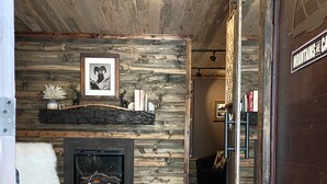 A rustic interior with a wooden wall, a fireplace, and a leather sofa. - Cozy modern rustic 1-bedroom studio in Idyllwild.  Perfect hideout close to town (Idyllwild-Pine Cove)