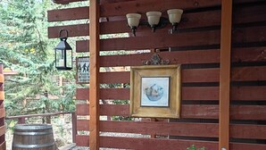 A wooden pergola with a bench, a wall-mounted picture frame, and two barrels. - Cozy modern rustic 1-bedroom studio in Idyllwild.  Perfect hideout close to town (Idyllwild-Pine Cove)