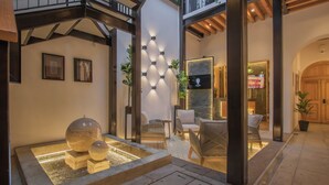 A modern indoor courtyard with a water feature, seating area, and a view of the outside. - Casa Ziña (Oaxaca)