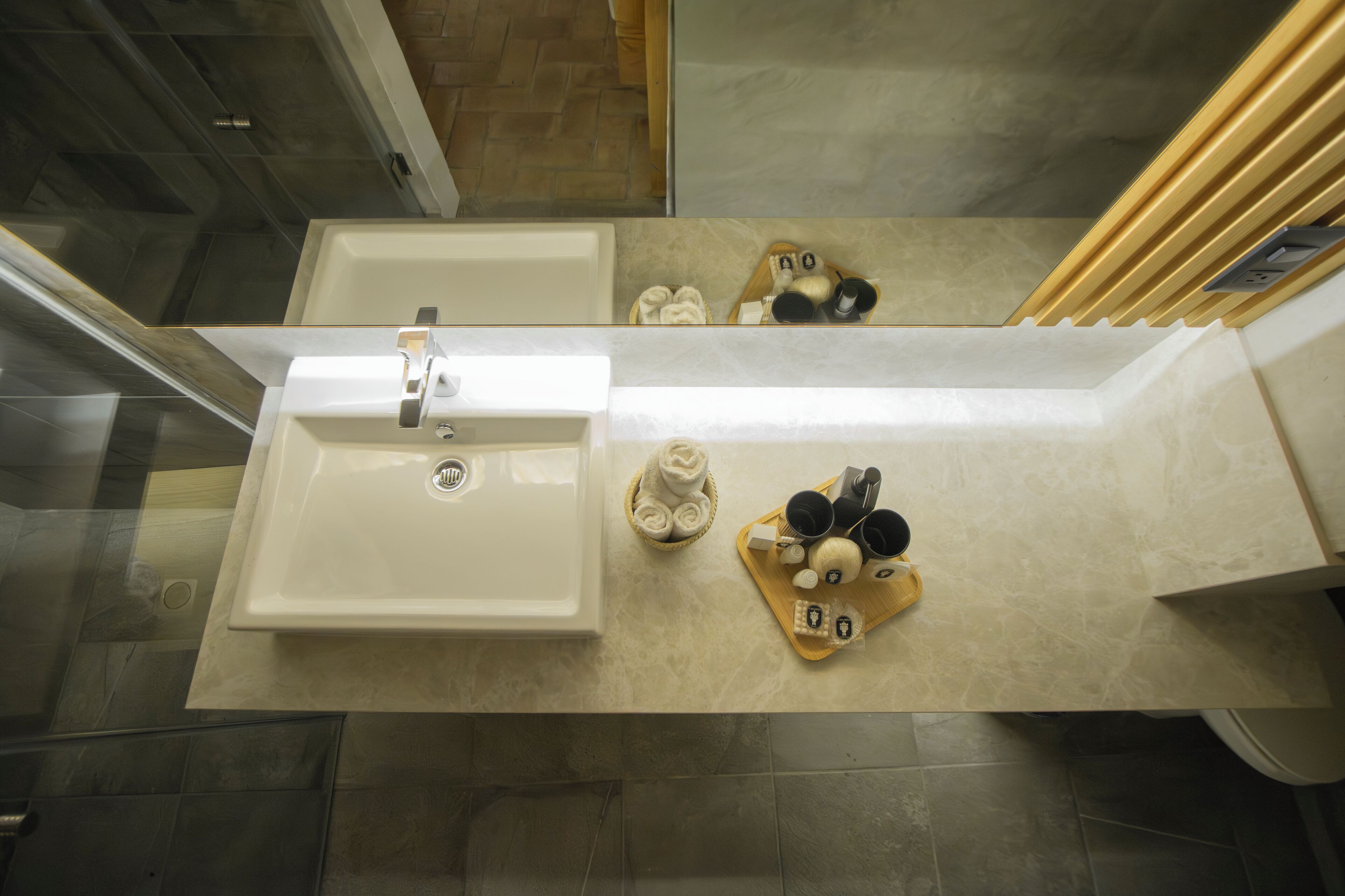 A bathroom with a large sink, a mirror, and a towel rack.