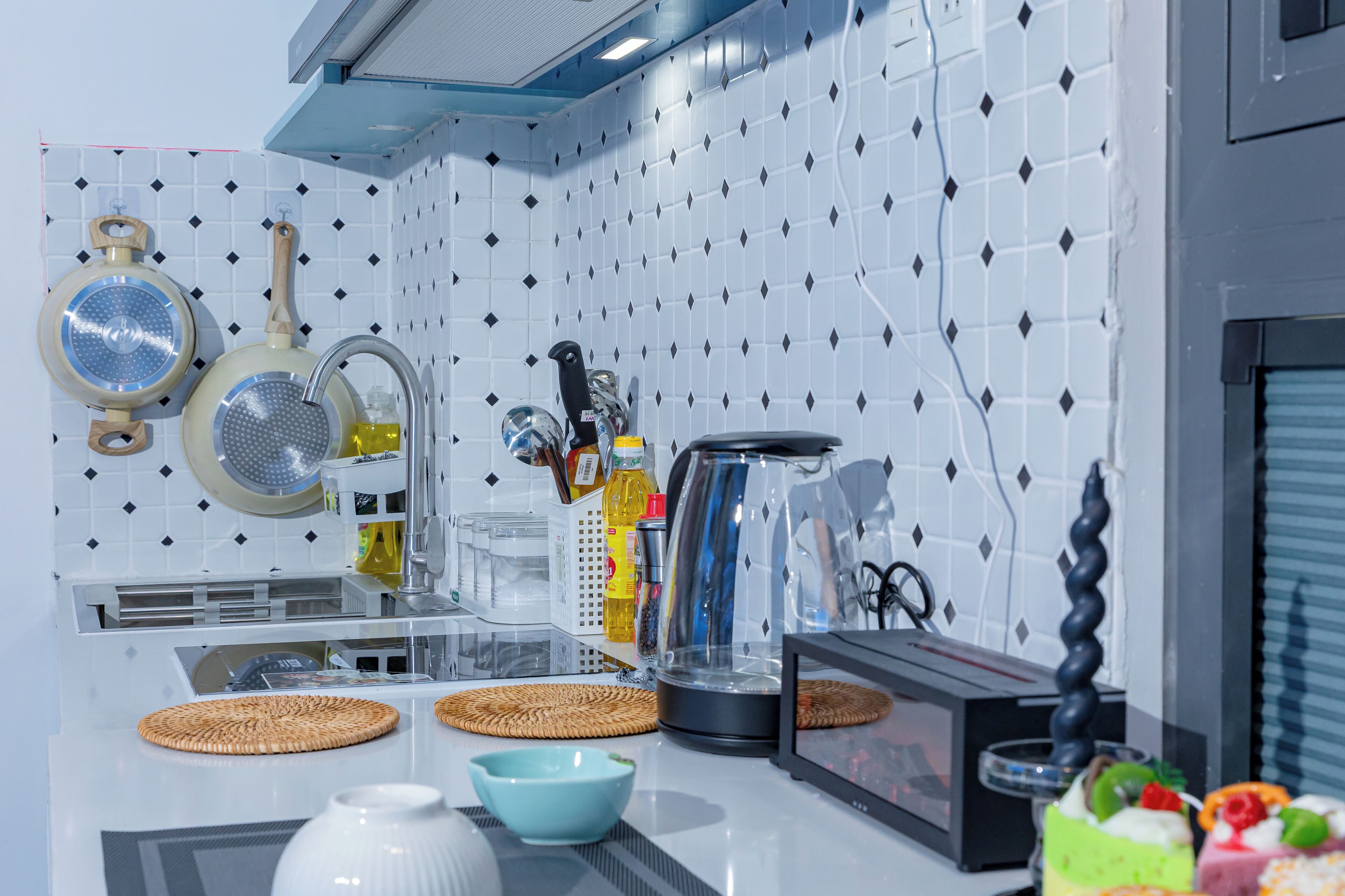 A modern kitchen with white tiled backsplash, stainless steel appliances, and various kitchen utensils.