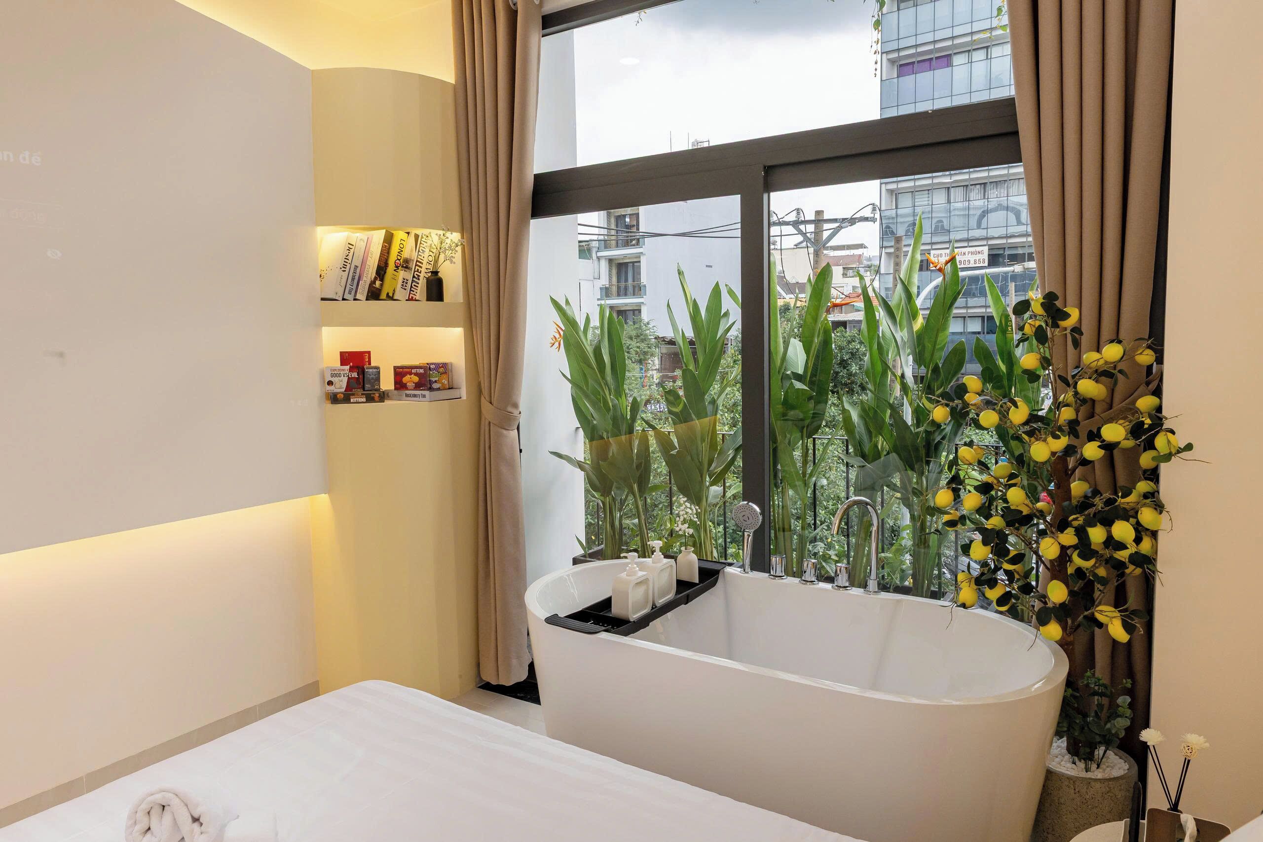 A modern bathroom with a freestanding bathtub, a large window with curtains, and a view of the cityscape.