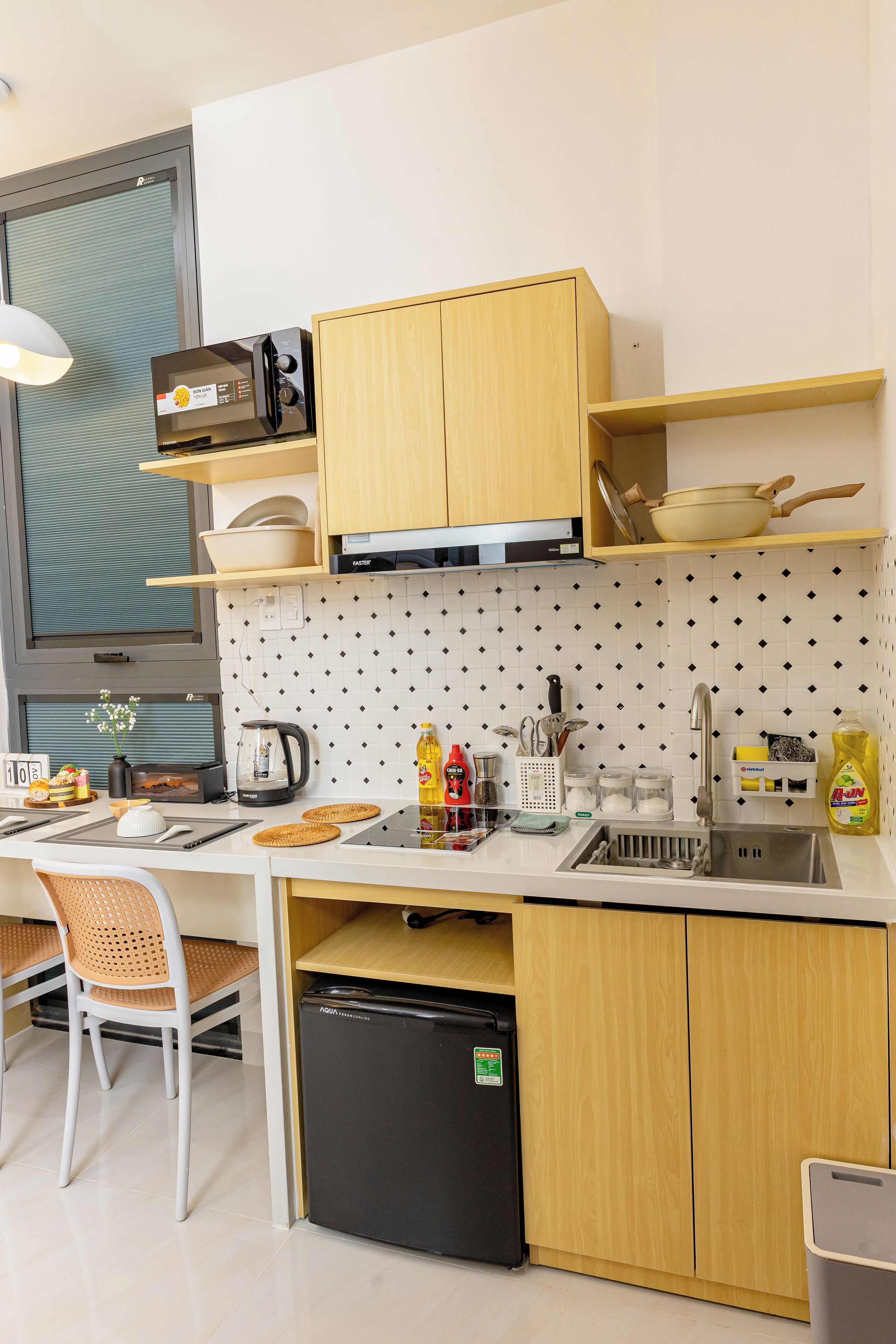 A compact kitchen with wooden cabinets, a black dishwasher, and a sink.