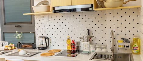 A compact kitchen with wooden cabinets, a black dishwasher, and a sink.
