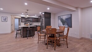 Una cocina moderna con armarios de madera oscura, electrodomésticos de acero inoxidable y una isla central con taburetes.