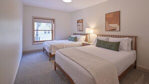Habitación de hotel con dos camas, una ventana y obras de arte en las paredes.