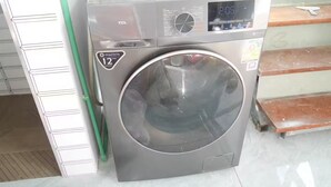 A front-loading washing machine with a digital display, a 12-year warranty label, and a control panel with various settings. - Fantastic 3-bedroom with AC in charming in Pattaya Chon Buri (Chon Buri)