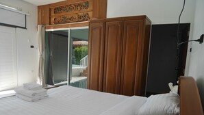 A bedroom with a bed, a wardrobe, and a sliding glass door leading to a balcony. - Fantastic 3-bedroom with AC in charming in Pattaya Chon Buri (Chon Buri)