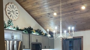 A modern kitchen with a central island, stainless steel appliances, and a wooden ceiling. - Murphy House at Pickwick (Tishomingo County)